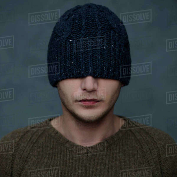 Caucasian man wearing beanie hat over eyes Stock Photo Dissolve