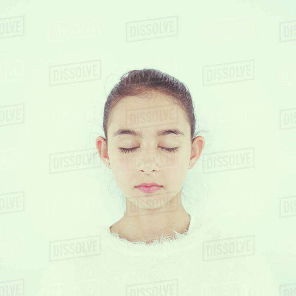 Close up of mixed race girl with eyes closed Stock Photo Dissolve