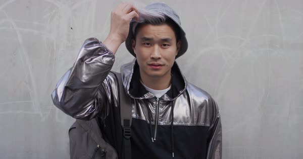 Portrait Of Attractive Young Asian Man Fixing Hair Wearing Stylish