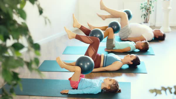 At home, mom, dad, son and daughter engaged in physical education