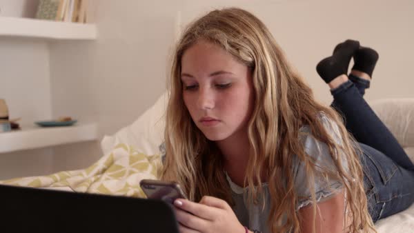 teenage-girl-lying-on-her-bed