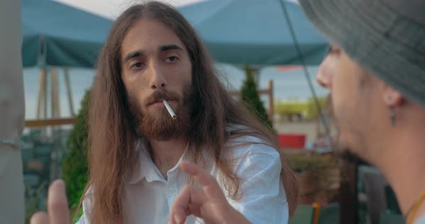 Two Friends In Outdoor Cafe Long Haired Man With Beard And Guy In