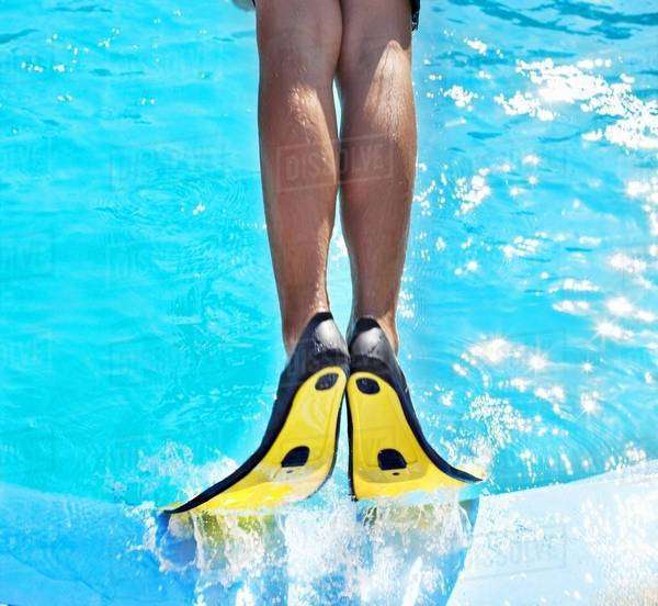 Man wearing fins in swimming pool Stock Photo Dissolve