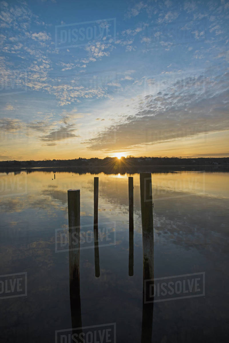 USA, Massachusetts, Cape Cod, Eastham, Mooring posts in lake at sunrise