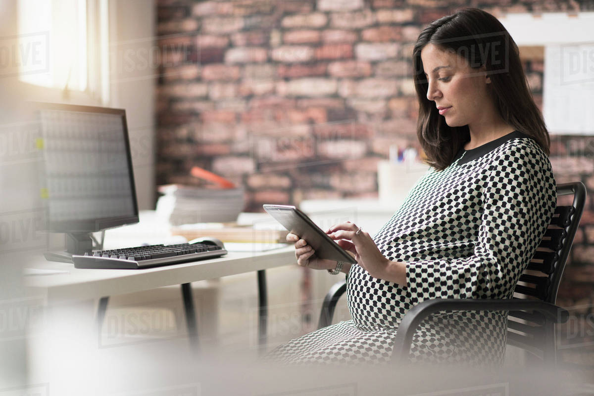 Pregnant woman working in office Stock Photo Dissolve