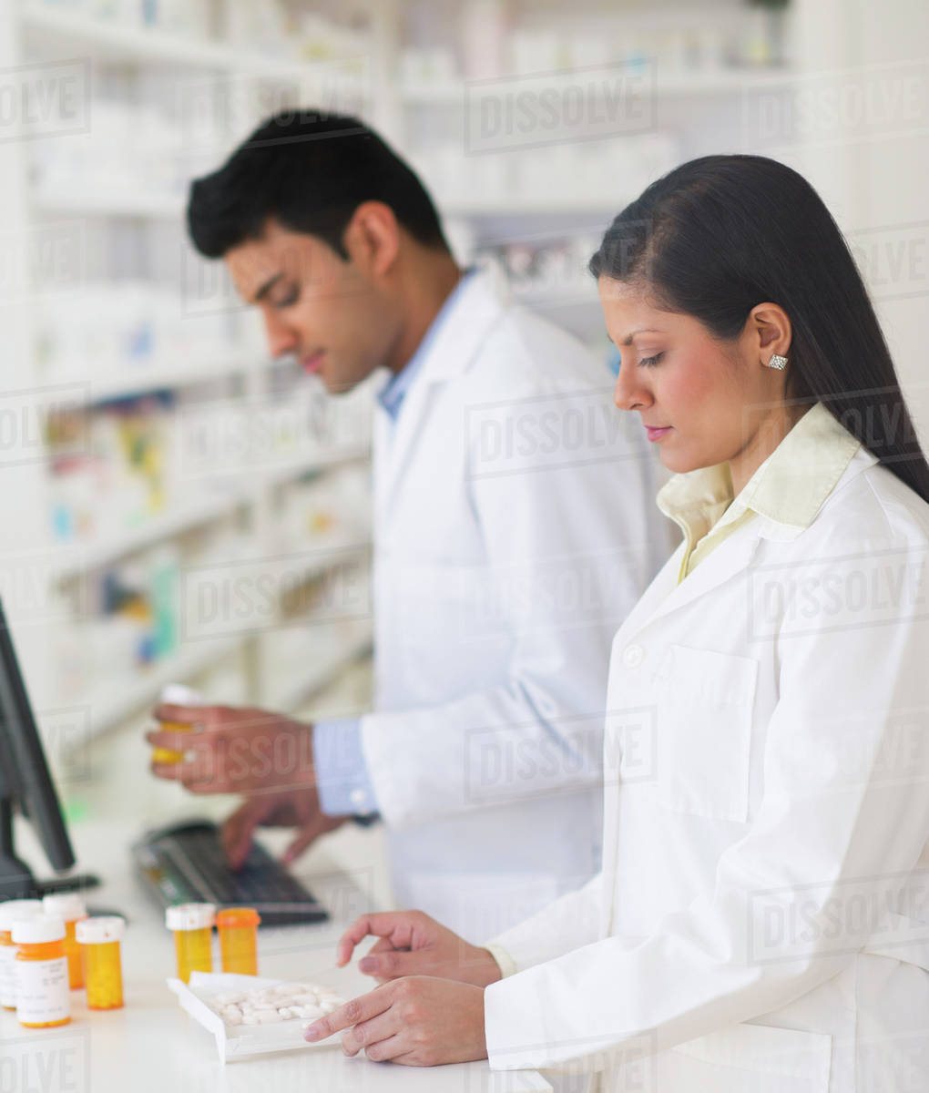 Two pharmacists in pharmacy Stock Photo Dissolve