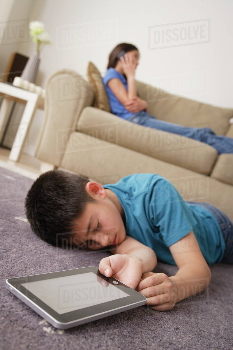 Boy sleeping on floor with iPad in hand Stock Photo Dissolve