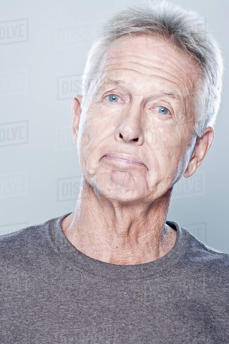 Portrait of confused senior man, studio shot - Stock Photo - Dissolve