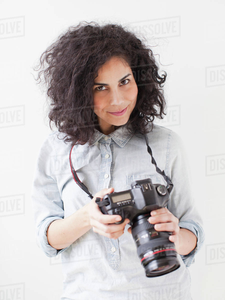 Portrait of beautiful young woman holding professional camera
