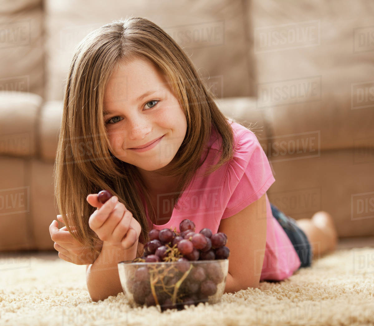 USA, Utah, Lehi, Portrait of girl (1011) lying on rug, eating red