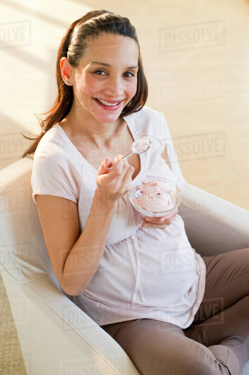 Pregnant woman eating a bowl of ice cream Stock Photo Dissolve