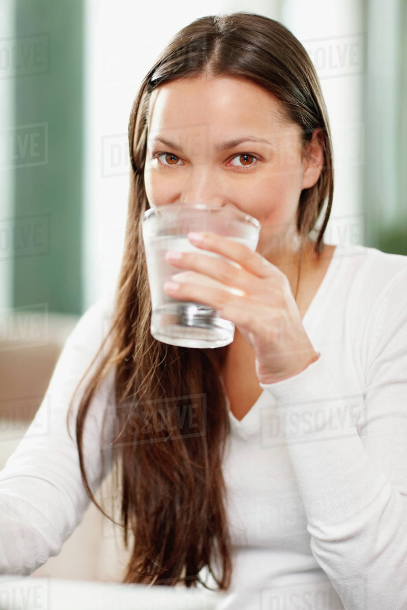Woman drinking a glass of water Stock Photo Dissolve