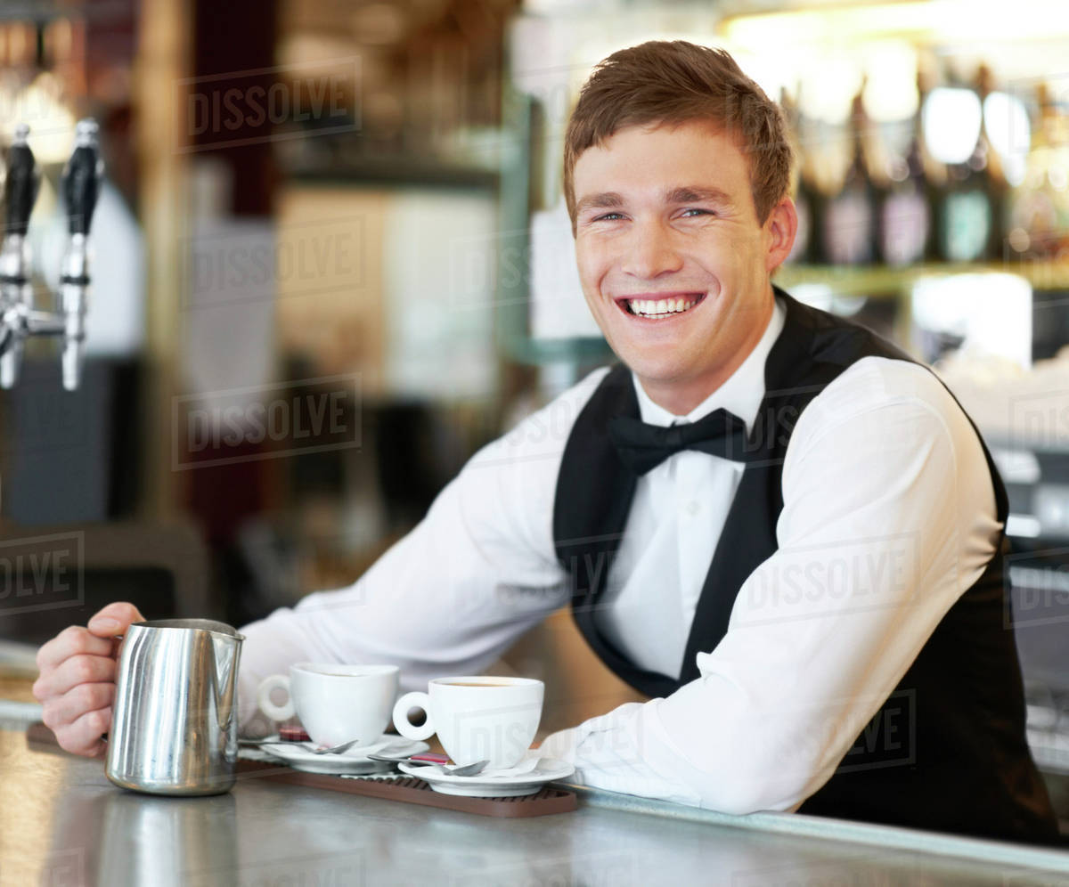 Portrait of barista holding milk jug Stock Photo Dissolve