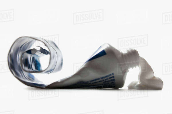 Half empty toothpaste tube spilling - Stock Photo - Dissolve