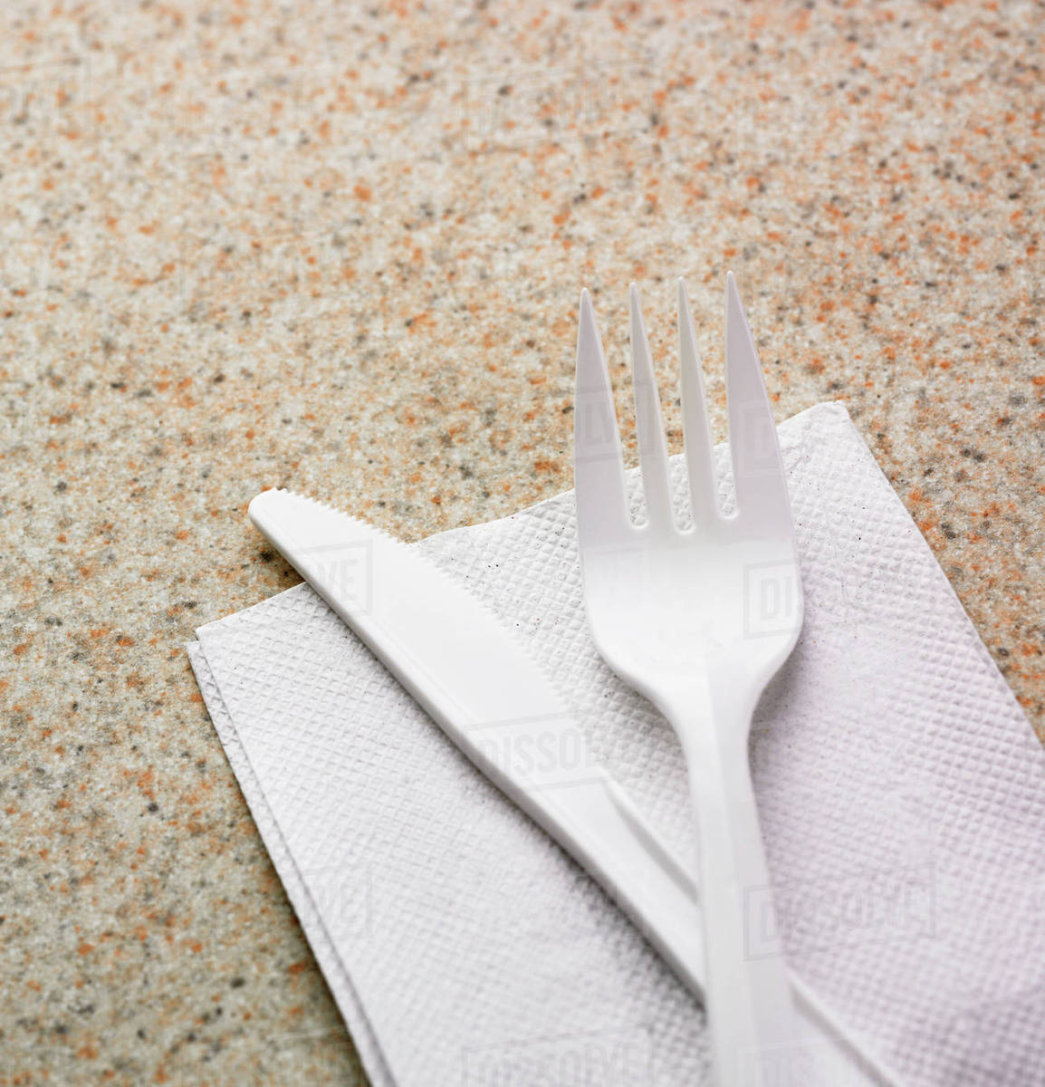 Close up of plastic knife and fork on napkin Stock Photo Dissolve