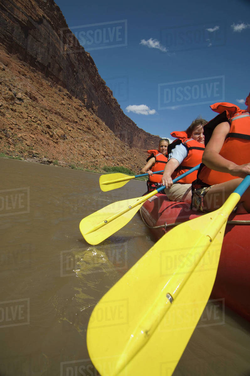 People paddling in raft Stock Photo Dissolve
