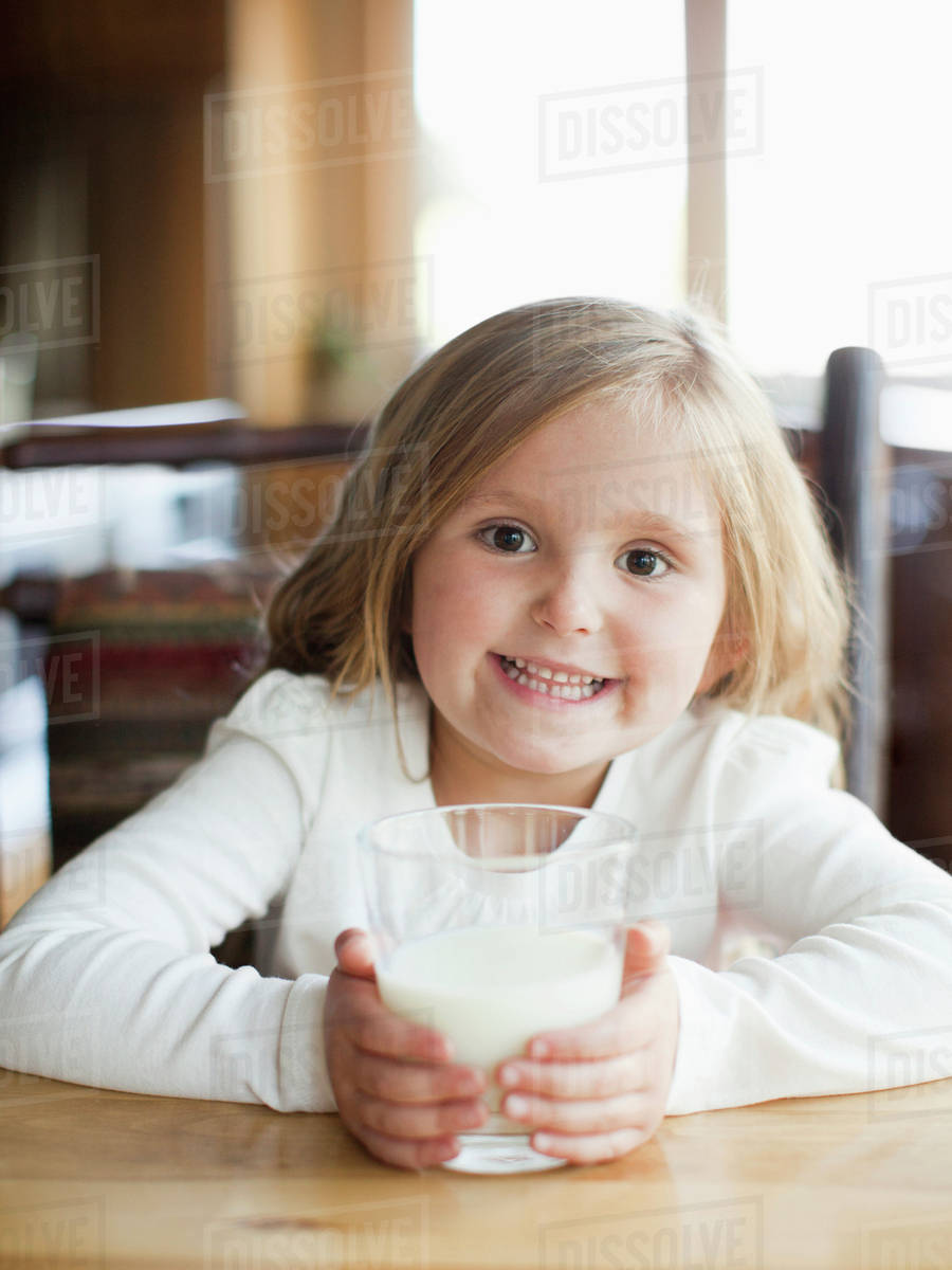 Girl (45) drinking milk in kitchen Stock Photo Dissolve