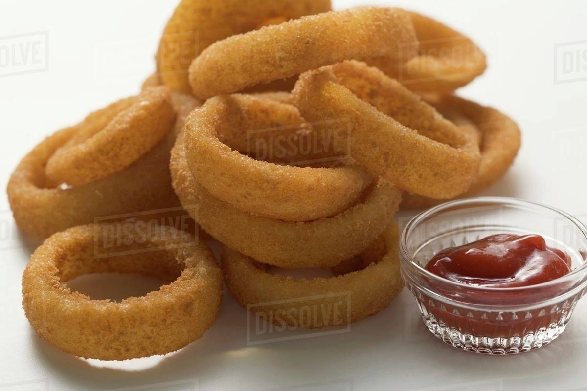 Deepfried onion rings with ketchup Stock Photo Dissolve