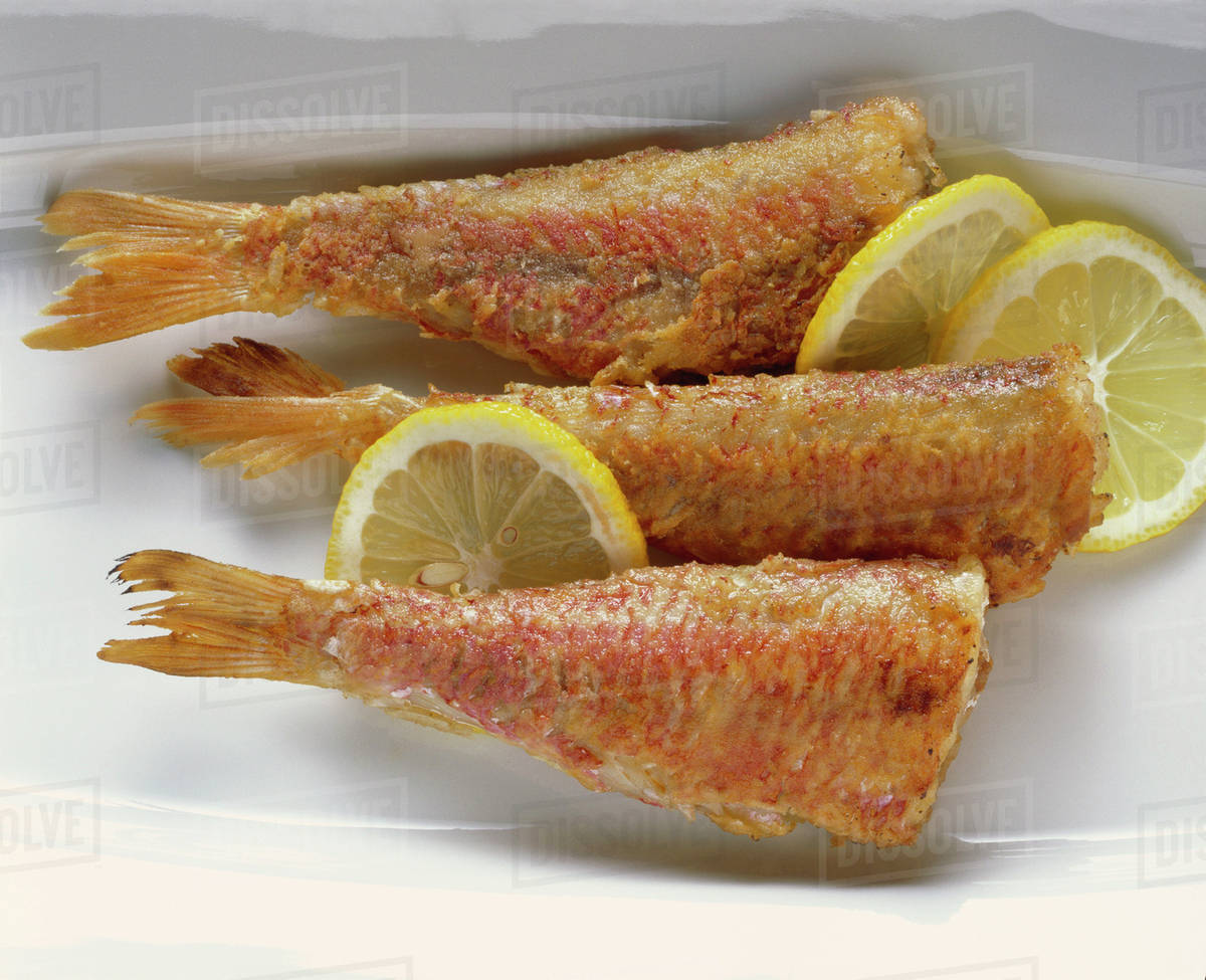 Roasted red mullets with lemon slices Stock Photo Dissolve