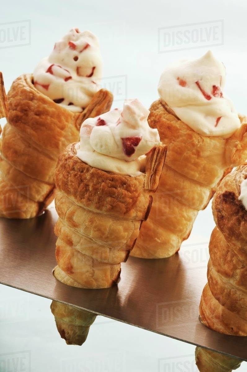 Puff pastry cones filled with cream Stock Photo Dissolve
