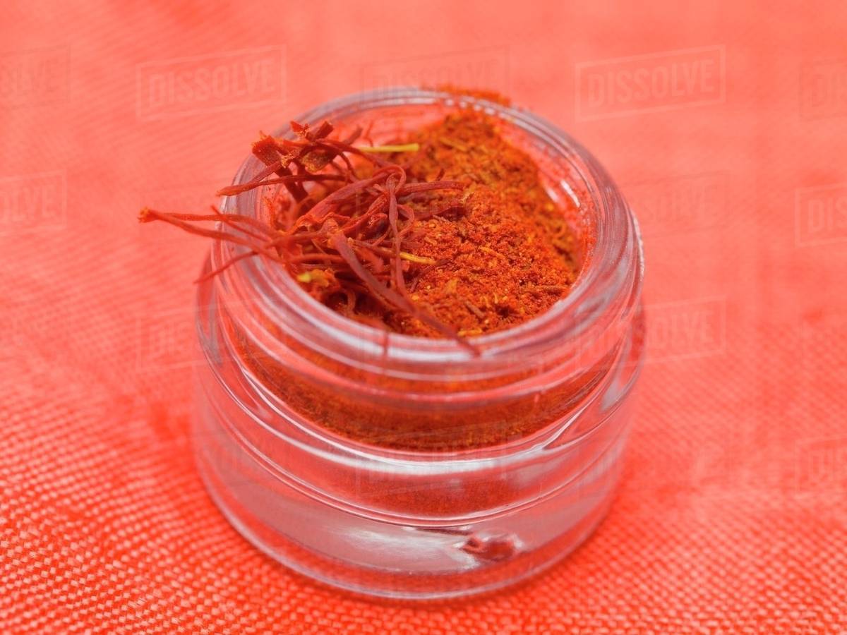 Saffron powder and saffron threads in screwtop jar Stock Photo Dissolve