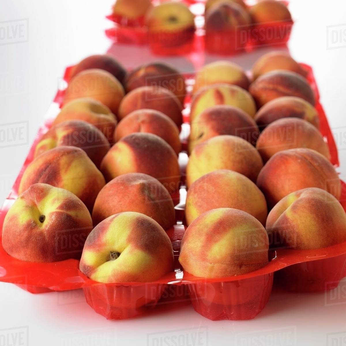 Peaches in plastic tray Stock Photo Dissolve