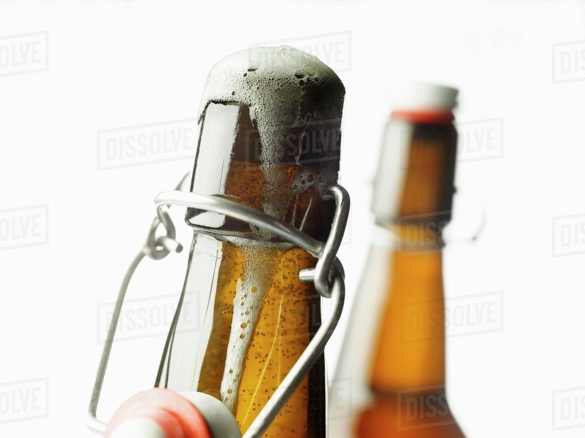 Fliptop bottle with beer frothing out Stock Photo Dissolve