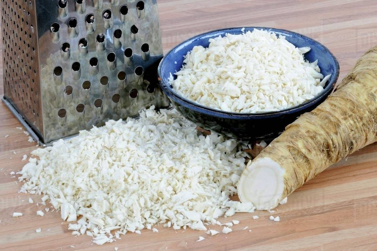 Horseradish, whole and grated with a grater Stock Photo Dissolve