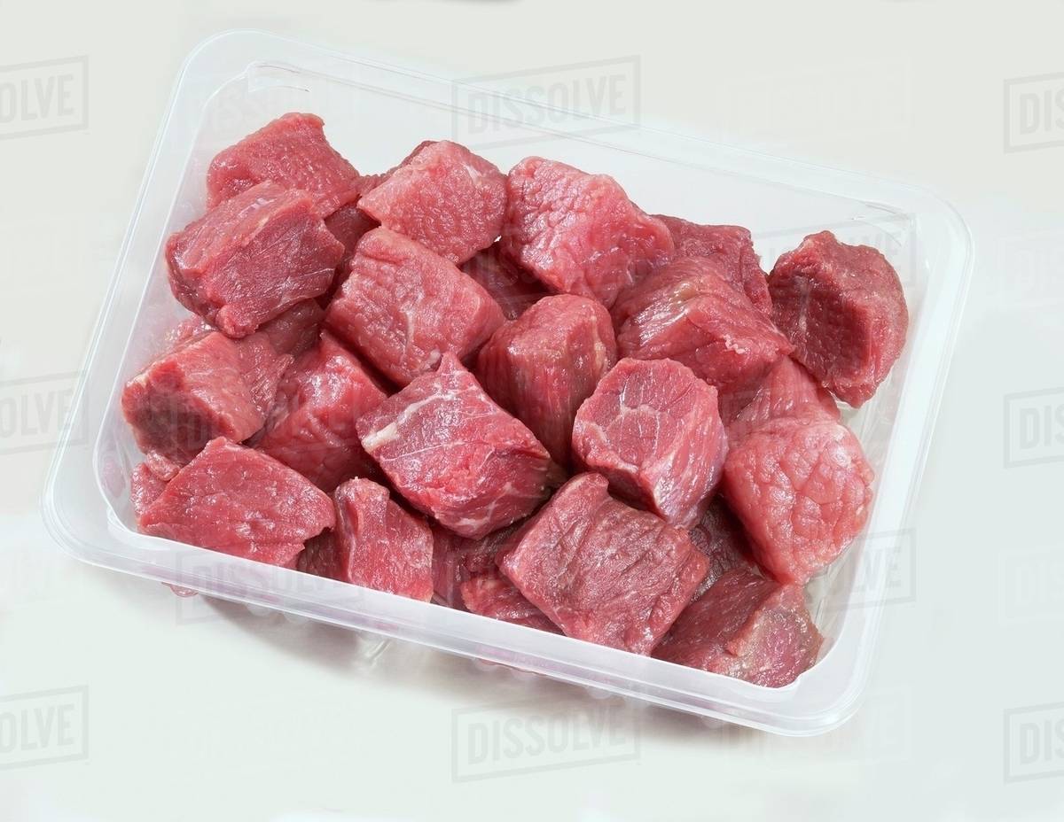 Diced beef in plastic container Stock Photo Dissolve