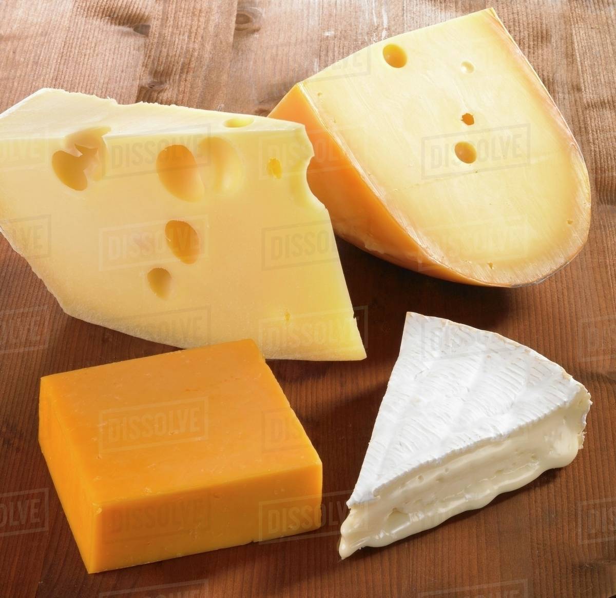 Four pieces of cheese (Emmentaler, Gouda, Cheddar and Brie) Stock