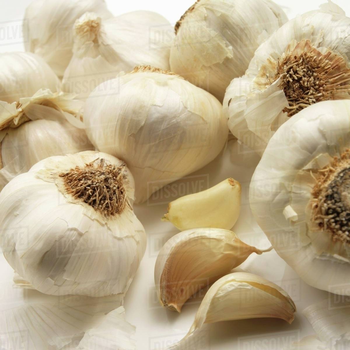 Whole garlic bulbs and three cloves of garlic Stock Photo Dissolve