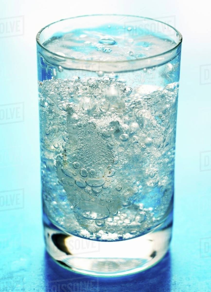 A glass of mineral water with ice cubes Stock Photo Dissolve