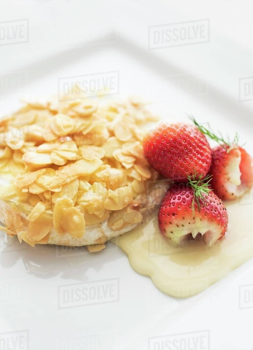 Brie cheese with roasted almonds and fresh strawberries Stock Photo