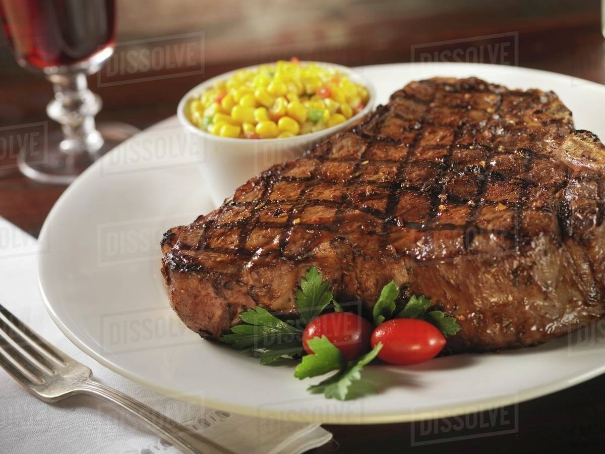 Grilled Porterhouse Steak with a Side of Corn Stock Photo Dissolve