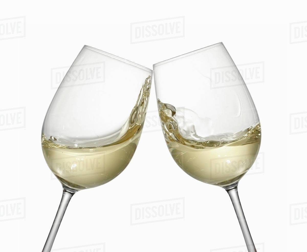 White wine glasses being clinked together Stock Photo Dissolve