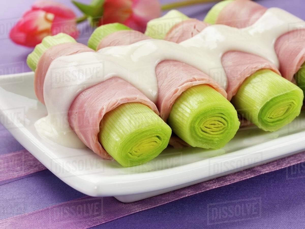 Leeks wrapped in ham with bechamel sauce Stock Photo Dissolve