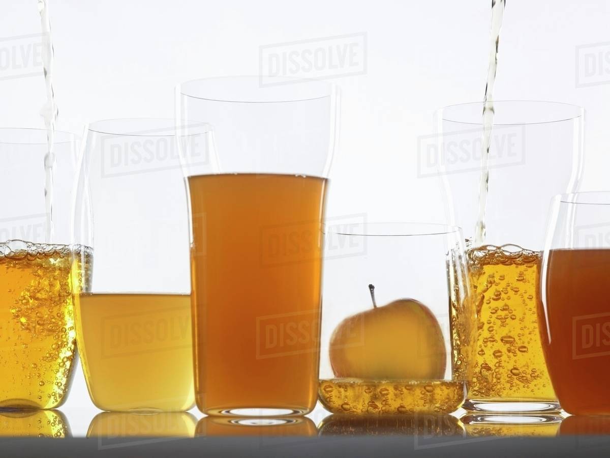 Assorted clear and cloudy apple juices in glasses Stock Photo Dissolve