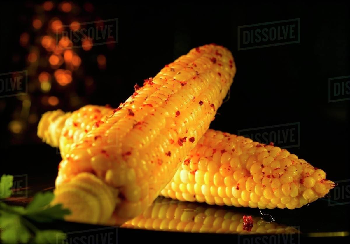 Corn on the cob with red peppercorns Stock Photo Dissolve