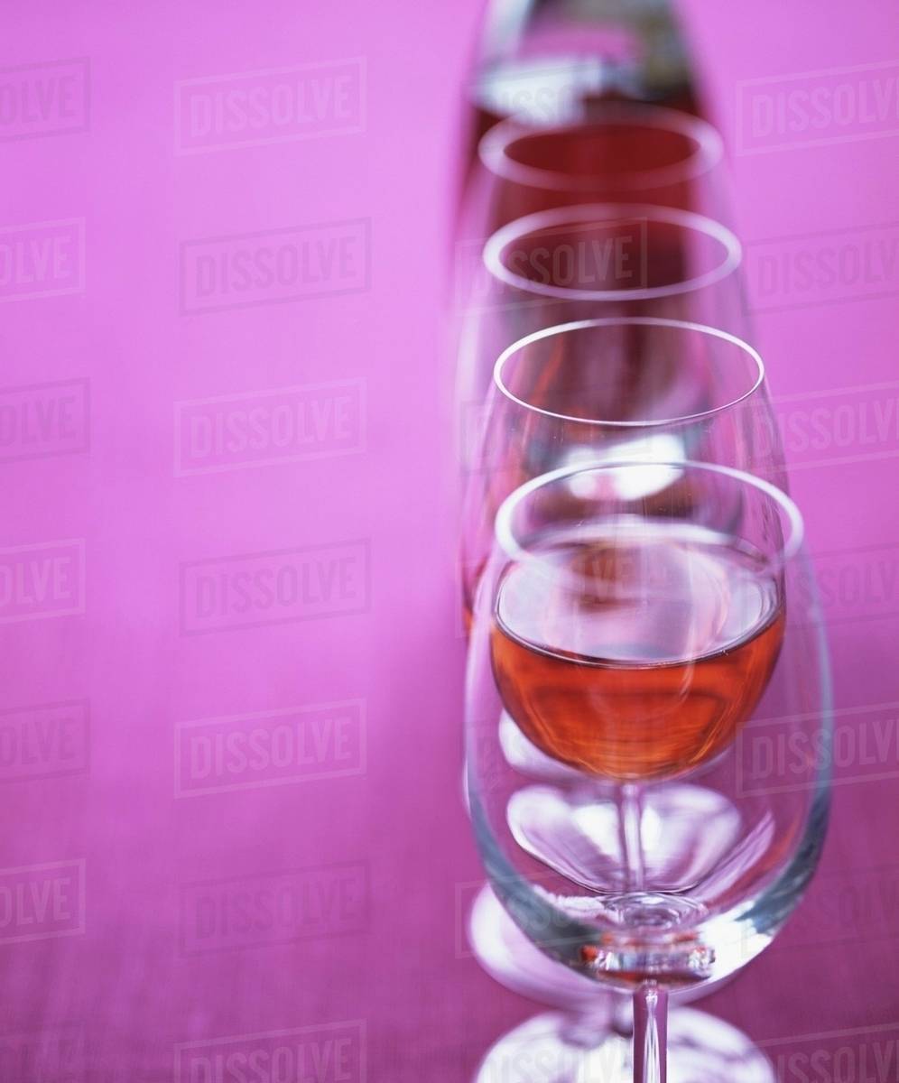 Rose wine glasses in a row Stock Photo Dissolve