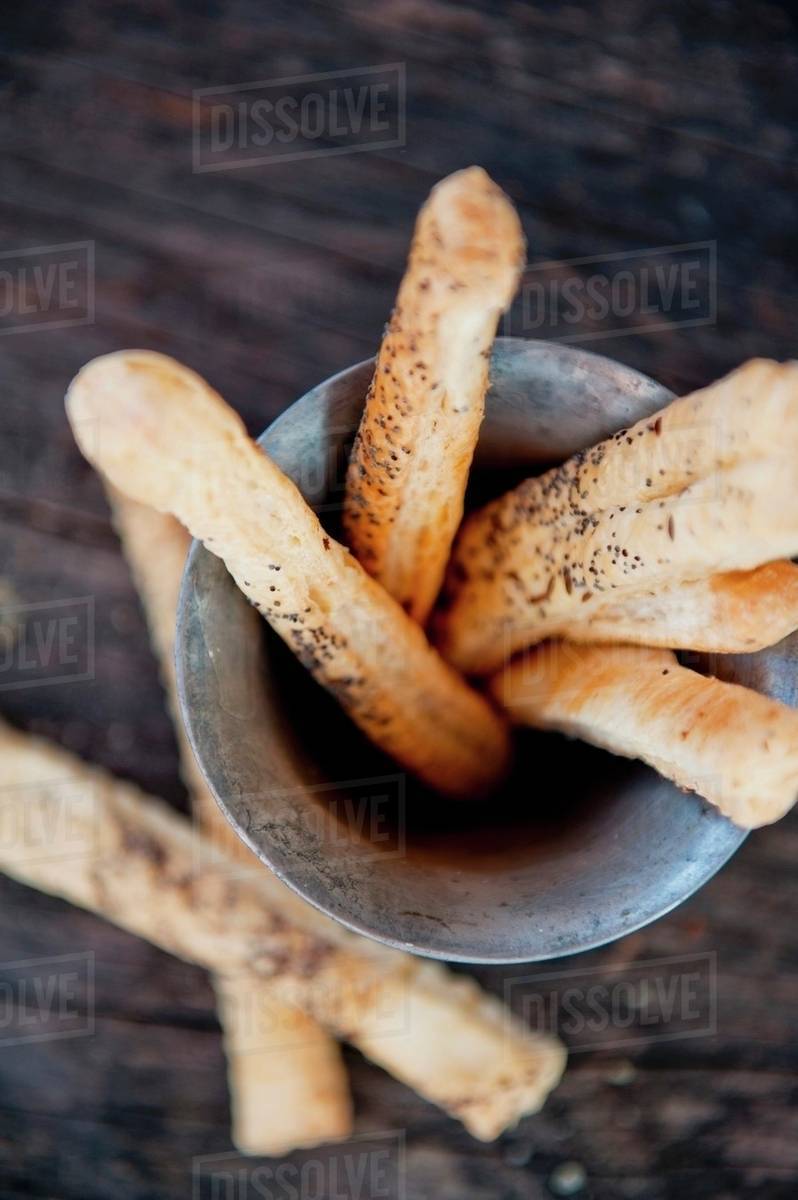 Poppy seed breadsticks in a metal container (view from above) Stock Photo Dissolve