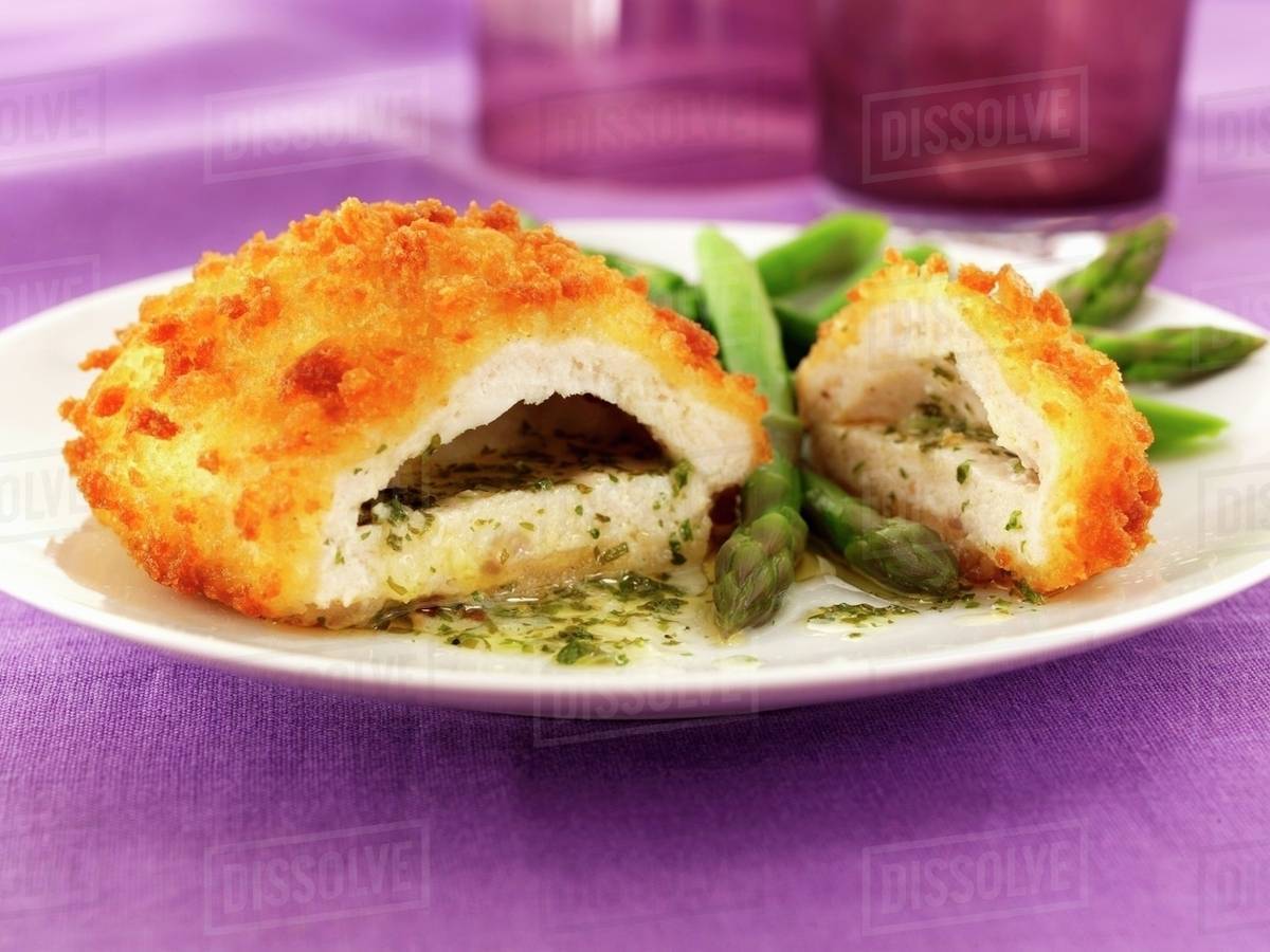 Chicken kiev with garlic butter, herbs and asparagus Stock Photo
