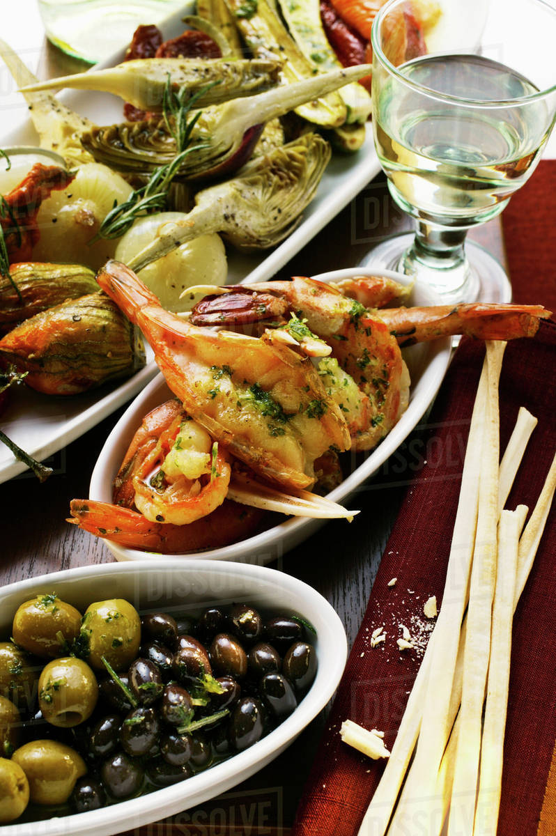 Antipasti platter, scampi and olives; grissini Stock Photo Dissolve