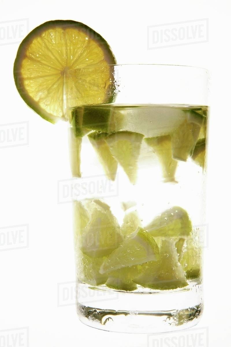 Mineral water with lime wedges, ice cubes & slice of lime - Royalty ...