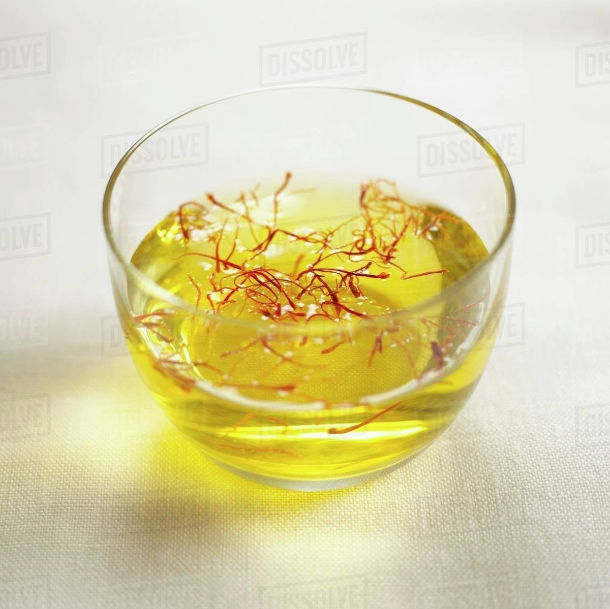 Saffron threads in a small bowl of water Stock Photo Dissolve