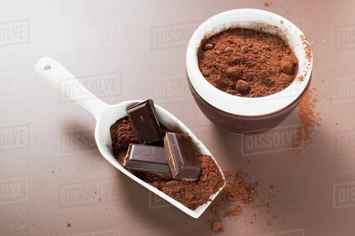 Pieces of chocolate and cocoa powder in scoop and bowl Stock Photo