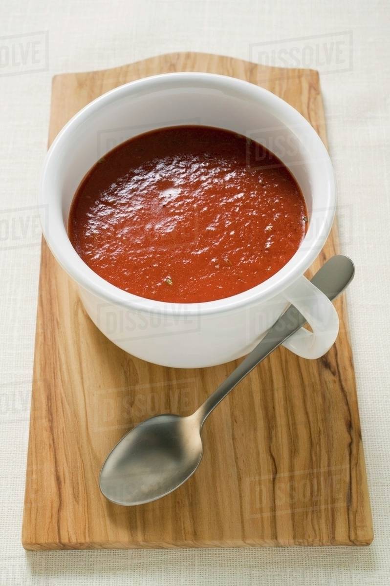 Tomato soup in cup on chopping board Stock Photo Dissolve