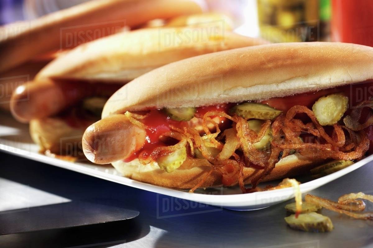 Hot dogs with fried onions and gherkins Stock Photo Dissolve