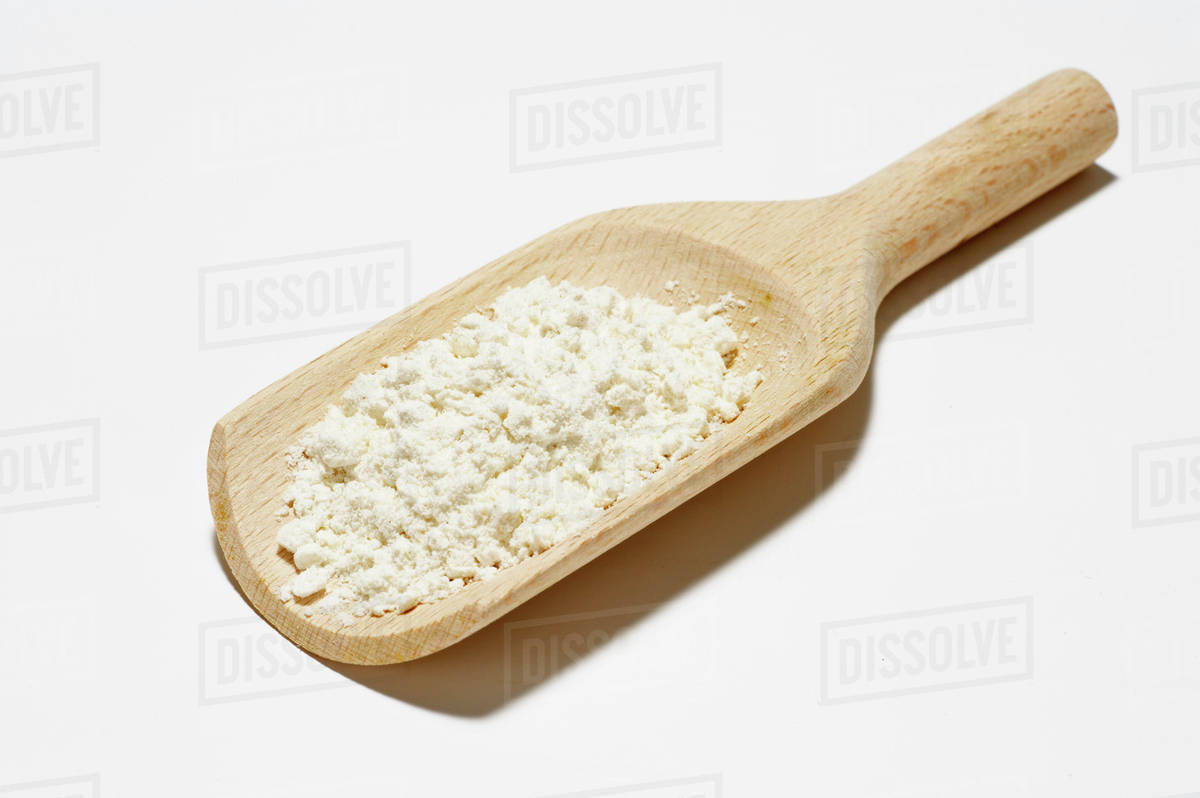 Flour on a wooden scoop - Stock Photo - Dissolve