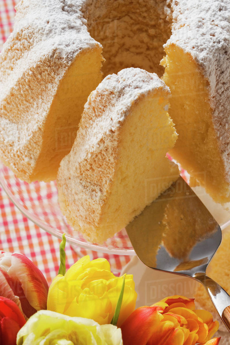 Ring cake with icing sugar, pieces cut Stock Photo Dissolve