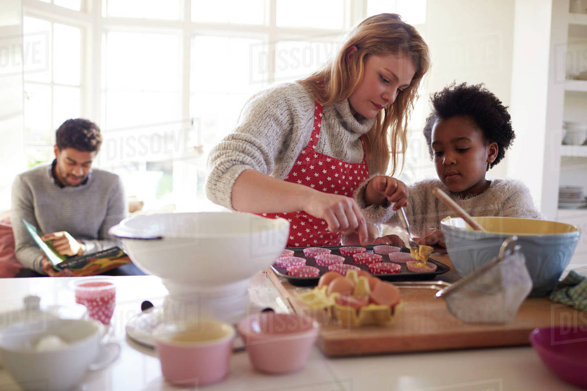 Family baking cake in kitchen at home together Stock Photo Dissolve